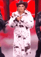 a woman wearing a cowboy hat and a fur coat with the letter p on it