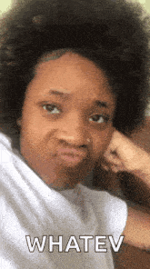 a woman with a big afro is making a funny face and saying `` whatev '' .