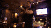 a man in a black shirt is holding a bottle of pills in front of him