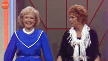 two women are standing next to each other in front of a buzz logo