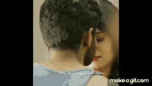 a man and a woman are kissing in front of a mirror