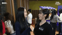 a group of girls are standing in front of a sign that says idol radio on it