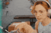 a woman wearing headphones looks at a box that says gato