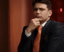 a man in a suit and tie is making a funny face .
