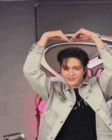 a man making a heart shape with his hands