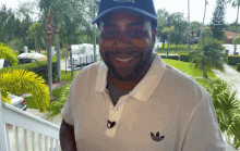 a man wearing a hat and a white adidas shirt