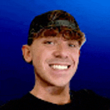 a young man wearing a baseball cap and a black shirt is smiling in front of a blue background .