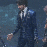 a man in a blue suit and tie stands next to a woman