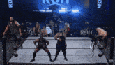 a group of wrestlers are in a ring with the word roh on the bottom