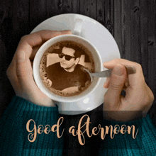 a person holding a cup of coffee with a picture of a man in it and the words good afternoon