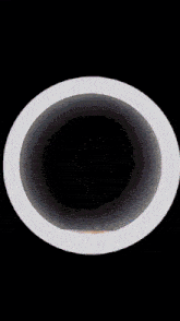 a white circle with a black hole in the middle of it
