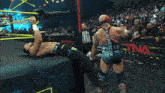 a wrestling match is being played in front of a sign that says hem