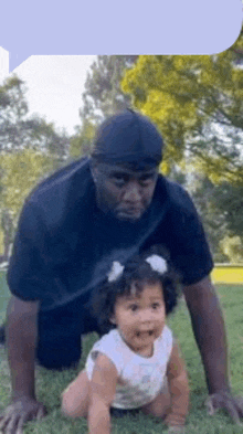 a man and a baby are crawling in the grass .