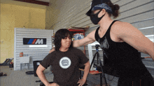 a man wearing a mask stands next to a woman wearing a t-shirt with a monkey on it