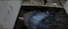 a group of people are standing in a dark room with a blue jellyfish coming out of the water .