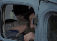 a man with a beard and mustache is sticking his head out of a car window