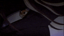 a close up of a person 's eye in a dark room with a purple background .