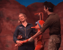 a woman in a space suit holds hands with a man in military uniform