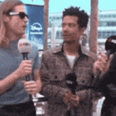 a man is holding a microphone and talking to another man