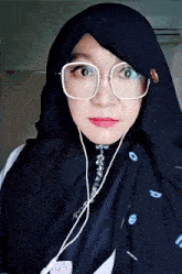 a woman wearing glasses and a scarf has the number 6 on it