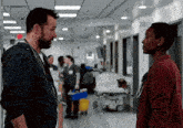 a man and a woman are standing in a hospital hallway talking