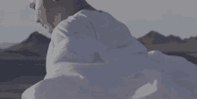 a man in a white shirt is standing in a desert