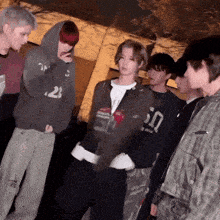 a group of young men are standing in a circle with one wearing a sweatshirt that says 50 on it