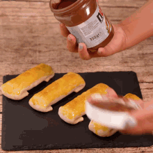 a person is spreading nutella on some pastries on a table