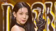 a woman wearing black gloves and a choker is giving a peace sign