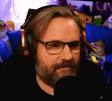 a man with glasses and a beard wearing headphones