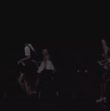 a woman with blue hair is dancing on a stage with other women