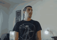 a man wearing a black t-shirt with a picture of a man playing a guitar