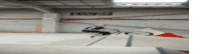a blurred image of a person riding a skateboard in a parking garage