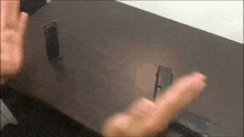 a person is holding a gun on a table with a lighter on it .