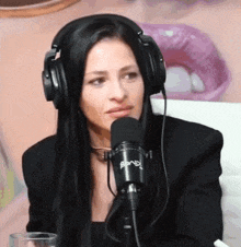 a woman wearing headphones is sitting in front of a microphone that says rmb on it
