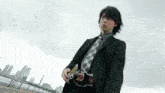 a man in a suit and tie is standing in front of a city skyline