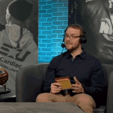 a man wearing headphones is sitting in front of a poster that says cardiac and unit