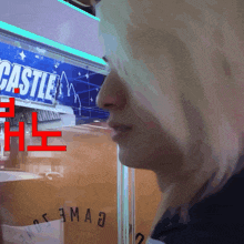 a woman stands in front of a sign that says castle on it
