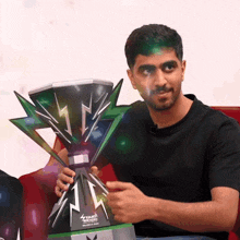 a man is holding a trophy that says ' touch ' on it