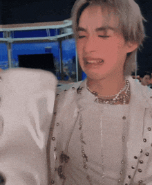 a man in a white jacket is crying while holding a white bag