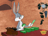 a cartoon of bugs bunny sitting at a table with lots of money and a looney tunes logo