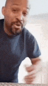 a man with a beard is cleaning a counter top with a sponge .