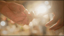 a man and woman holding hands with the sun shining through