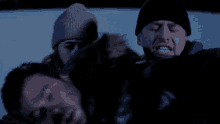 a woman in a beanie is laying on a man 's back