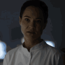 a woman in a white shirt is making a funny face