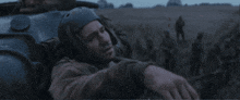 a man wearing a helmet is laying on the back of a vehicle