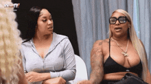 two women are sitting next to each other in a room talking .