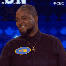 a man wearing a name tag that says toyin