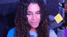 a girl with curly hair is sitting in front of a microphone and smiling .