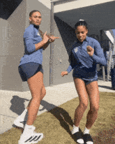 a woman in a blue jacket with a ucsd logo on it stands next to another woman in shorts